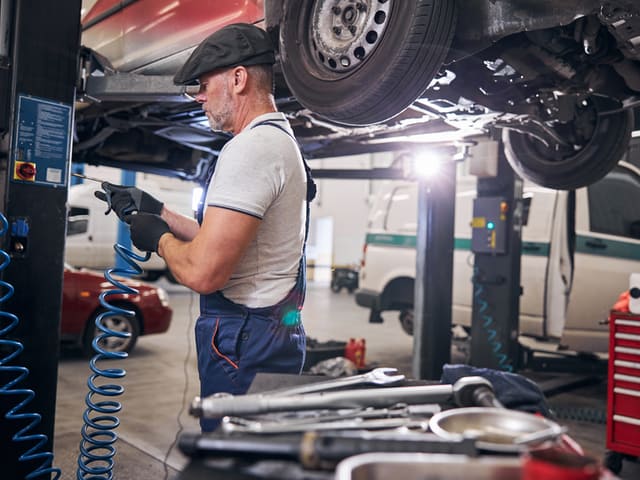 Mecánico revisando auto en taller